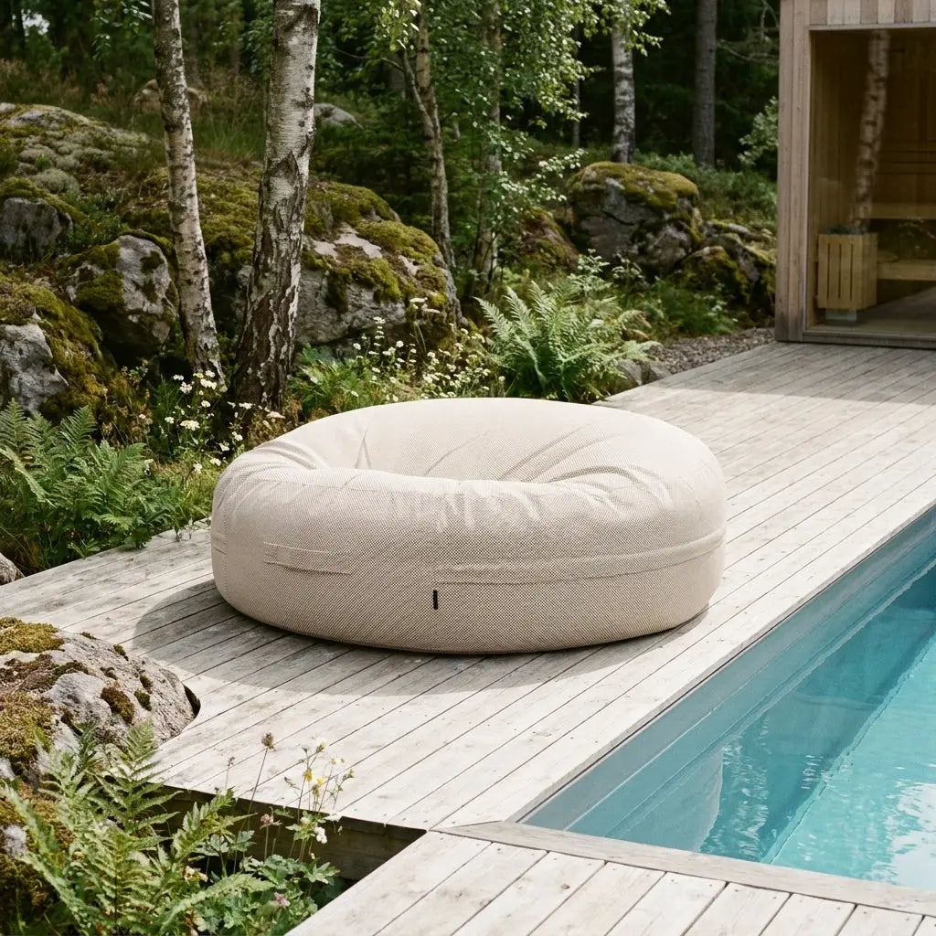 Jättesaccosäck Capri beige placerad vid poolen omgiven av natur.