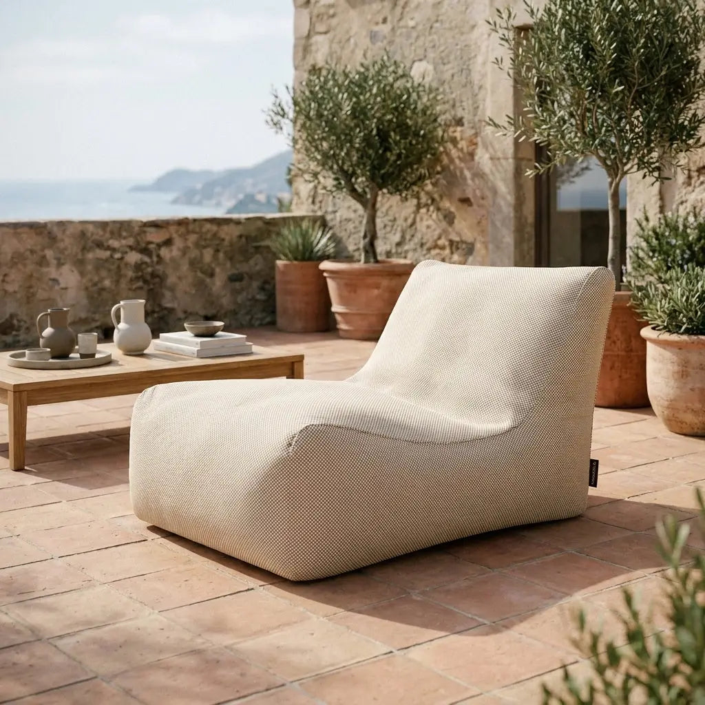 Beige sittsäck fåtölj Lounge 100 på en terrass med havsutsikt.