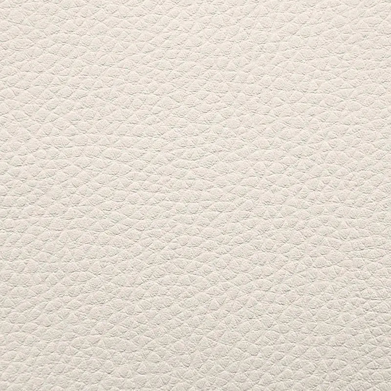 Närbild av vit, texturerad sittsäck fåtölj i Lounge 100-modell med läderliknande yta.
