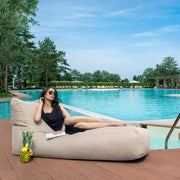 Sittsäck solsäng Riviera Beige vid poolen med kvinna som kopplar av i soligt väder.