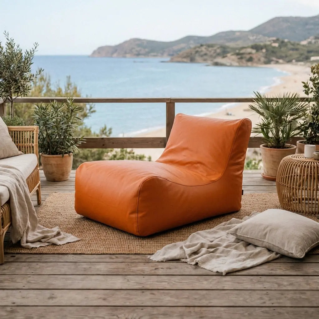 Sittsäck Lounge 100 utomhus orange på en terrass med havsutsikt och växter.