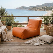 Sittsäck Lounge 100 utomhus orange på en terrass med havsutsikt och växter.