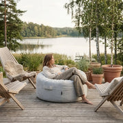 Saccosäck Riviera Light Grey på en uteplats med sjöutsikt, perfekt för avkoppling.